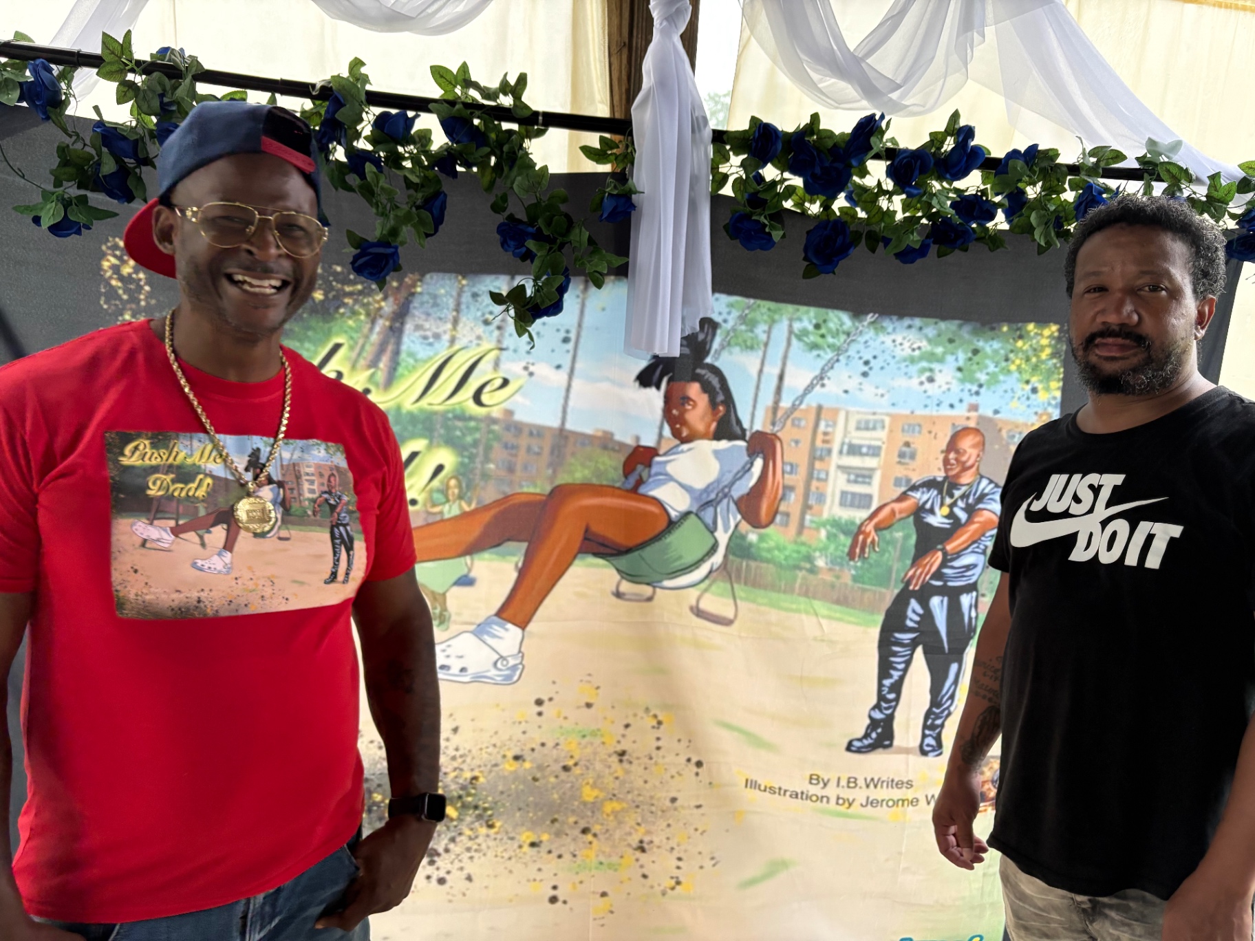 Two Black fathers smiling beside the Push Me Dad book banner illustrated by Jerome White